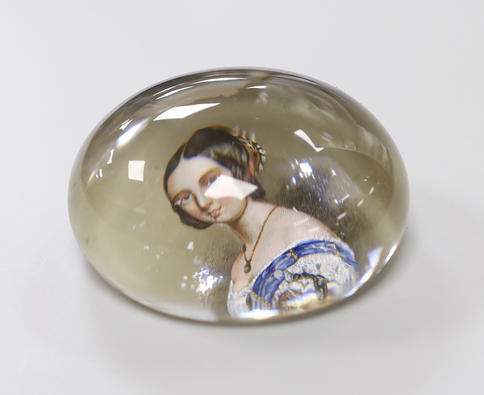 A Queen Victoria reverse decorated glass paperweight, approximately 7.5cm diameter